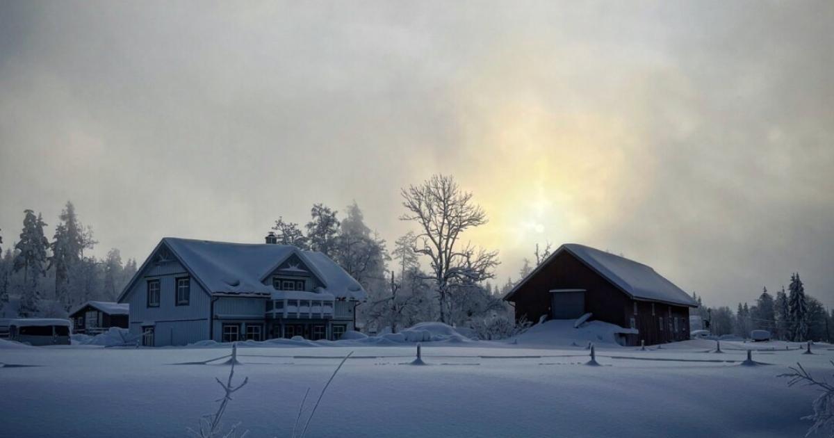 Sun over houses in winter landscape